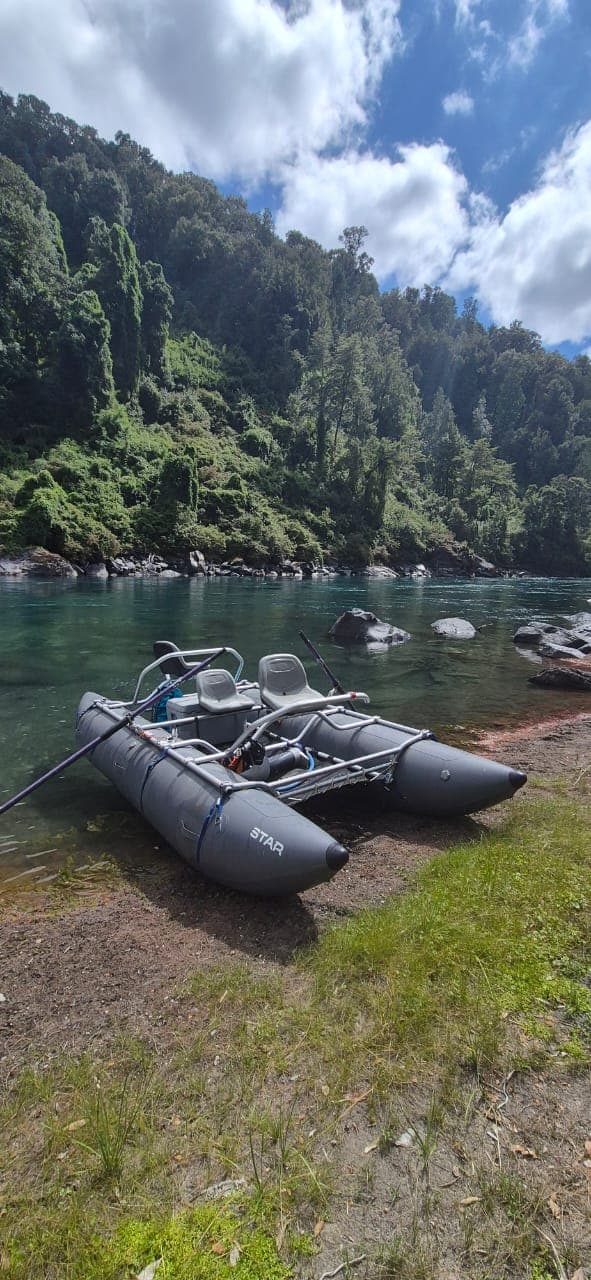 Balsa varada en la orilla del río con paredes de cañón verde
